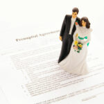 A newly married couple, bride and groom, standing on a prenuptial agreement